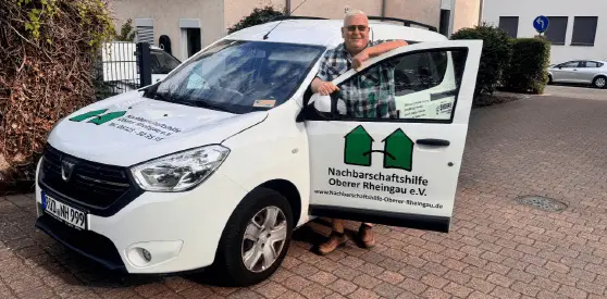 Fahrzeug der Nachbarschaftshilfe vor einem Gebäude geparkt.